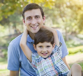 Smiling father sitting with young son